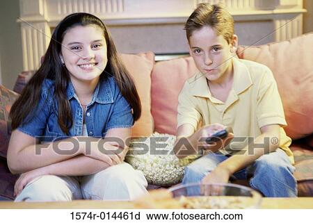 Close-up of a brother and sister watching television View Large Photo Image Stock Image - Close-up of a brother and sister watching television. Fotosearch
