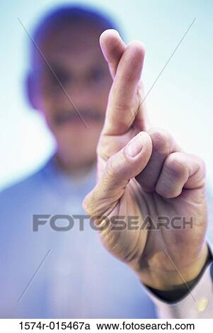 Stock Image - Close-up of a businessman's fingers crossed. Fotosearch