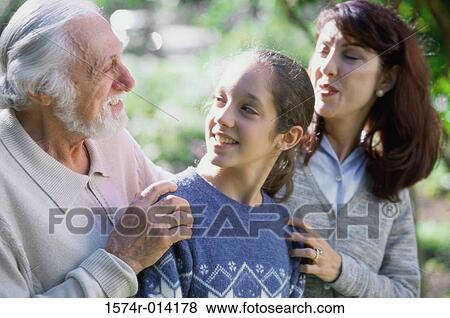Stock Photo - Close-up of a daughter with her mother and grandfather smiling. Fotosearch