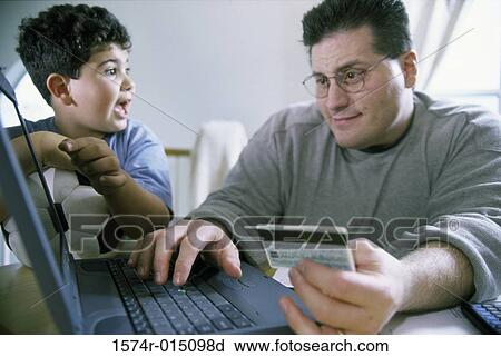 Close-up of a father and son sitting in front of a laptop View Large Photo Image Stock Image - Close-up of a father and son sitting in front of a laptop. Fotosearch