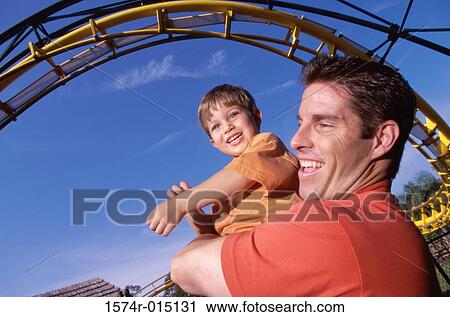 Close-up of a father carrying his son in an amusement park View Large Photo Image Stock Image - Close-up of a father carrying his son in an amusement park. Fotosearch