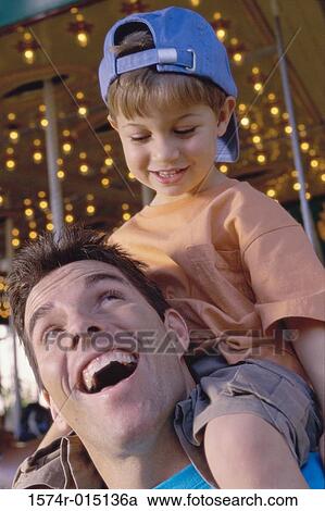 Close-up of a father carrying his son on his shoulders View Large Photo Image Stock Image - Close-up of a father carrying his son on his shoulders. Fotosearch