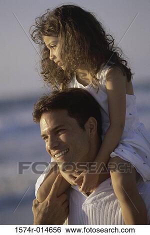Close-up of a father carrying his daughter on his shoulders at the beach View Large Photo Image Stock Photograph - Close-up of a father carrying his daughter on his shoulders at the beach. Fotosearch