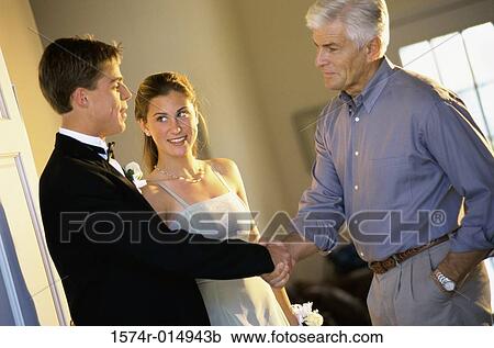 Stock Image - Close-up of a father shaking hands with his daughter's date. Fotosearch