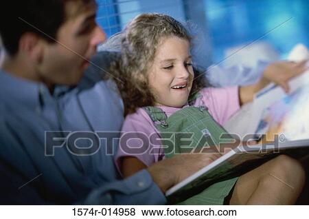 Close-up of a father teaching his daughter View Large Photo Image Stock Photo - Close-up of a father teaching his daughter. Fotosearch