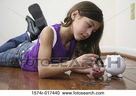 Stock Image - Close-up of a girl counting coins. Fotosearch