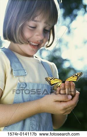 Stock Image - Close-up of a girl holding a butterfly. Fotosearch