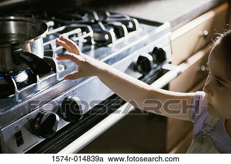 Close-up of a girl reaching out for a pan on a stove View Large Photo Image Stock Image - Close-up of a girl reaching out for a pan on a stove. Fotosearch