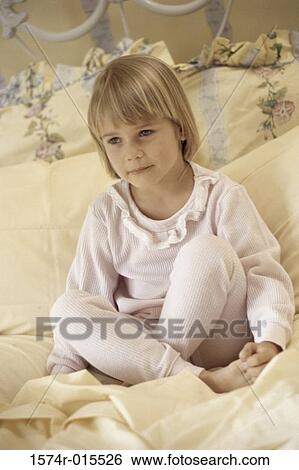 Close-up of a girl sitting on a bed View Large Photo Image Stock Photograph - Close-up of a girl sitting on a bed. Fotosearch