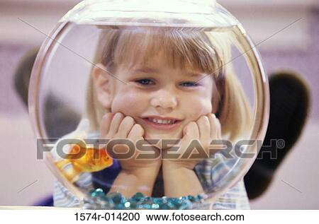 Close-up of a girl watching a goldfish in a fishbowl View Large Photo Image Stock Image - Close-up of a girl watching a goldfish in a fishbowl. Fotosearch