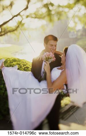 Close-up of a groom carrying his bride View Large Photo Image Stock Image - Close-up of a groom carrying his bride. Fotosearch