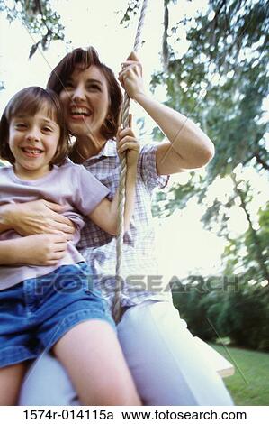 Close-up of a mother and daughter swinging on a rope swing View Large Photo Image Stock Image - Close-up of a mother and daughter swinging on a rope swing. Fotosearch