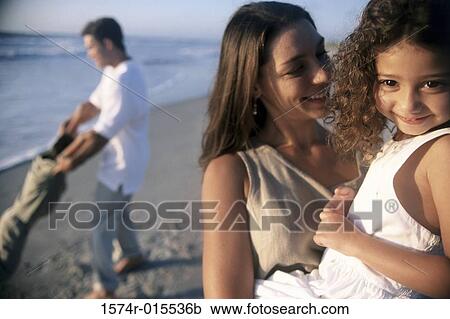 Close-up of a mother carrying her daughter on the beach View Large Photo Image Stock Image - Close-up of a mother carrying her daughter on the beach. Fotosearch