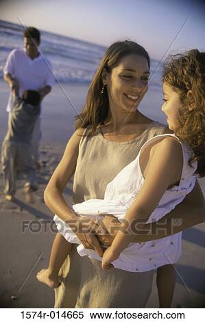 Close-up of a mother carrying her daughter on the beach View Large Photo Image Stock Photography - Close-up of a mother carrying her daughter on the beach. Fotosearch