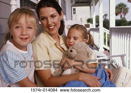 Close-up of a mother sitting with her two daughters View Large Photo Image Picture - Close-up of a mother sitting with her two daughters. Fotosearch