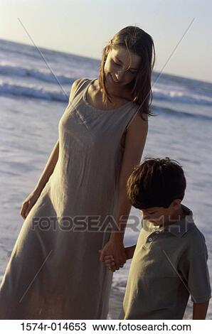 Close-up of a mother walking with her son on the beach View Large Photo Image Stock Image - Close-up of a mother walking with her son on the beach. Fotosearch