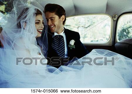 Stock Photograph - Close-up of a newlywed couple sitting in a car. Fotosearch