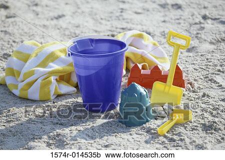 Stock Image - Close-up of a sand pail and a shovel on the beach. Fotosearch