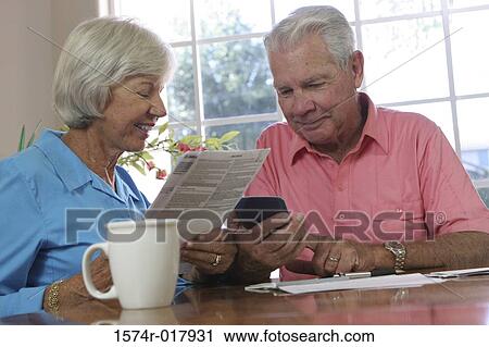 Close-up of a senior couple looking at a calculator View Large Photo Image Stock Image - Close-up of a senior couple looking at a calculator. Fotosearch