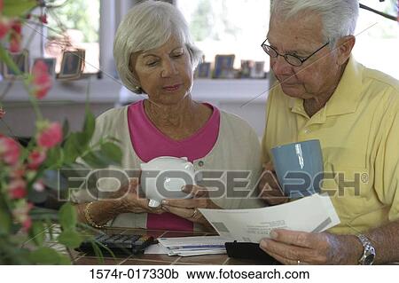 Close-up of a senior couple reading a bill View Large Photo Image Stock Image - Close-up of a senior couple reading a bill. Fotosearch