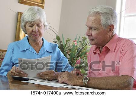 Close-up of a senior couple reading a bill View Large Photo Image Stock Image - Close-up of a senior couple reading a bill. Fotosearch