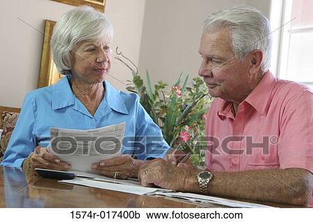 Close-up of a senior couple reading a bill View Large Photo Image Stock Image - Close-up of a senior couple reading a bill. Fotosearch