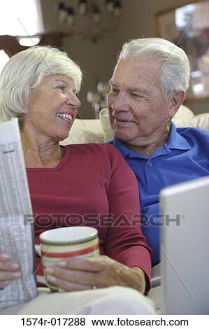 Close-up of a senior couple sitting on a couch smiling View Large Photo Image Stock Photo - Close-up of a senior couple sitting on a couch smiling. Fotosearch