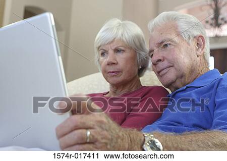 Close-up of a senior couple using a laptop View Large Photo Image Stock Image - Close-up of a senior couple using a laptop. Fotosearch