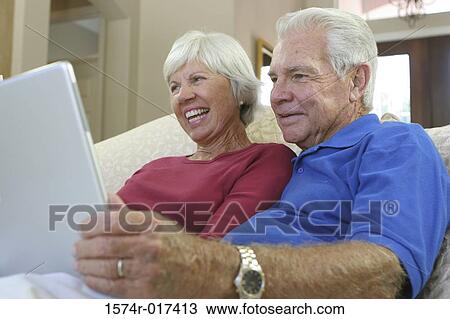 Close-up of a senior couple using a laptop View Large Photo Image Stock Image - Close-up of a senior couple using a laptop. Fotosearch