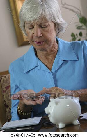 Stock Photography - Close-up of a senior woman counting coins. Fotosearch