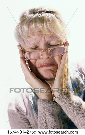 Stock Image - Close-up of a senior woman suffering from a headache. Fotosearch