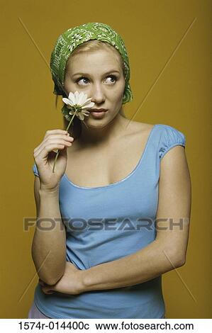 Stock Image - Close-up of a teenage girl holding a flower. Fotosearch