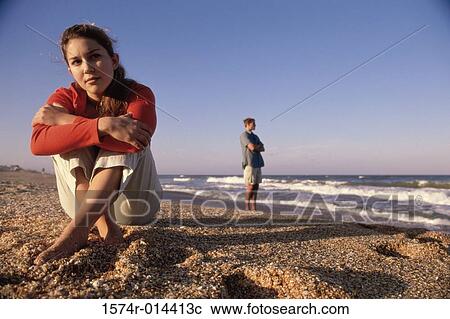 Stock Image - Close-up of a teenage girl sitting on the beach. Fotosearch