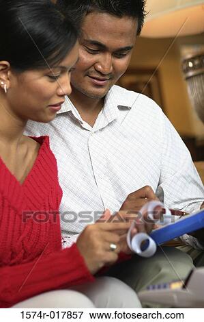 Close-up of a young couple reading a receipt View Large Photo Image Stock Photo - Close-up of a young couple reading a receipt. Fotosearch