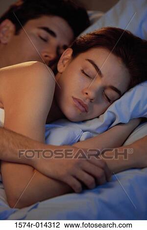 Close-up of a young couple sleeping in bed View Large Photo Image Stock Image - Close-up of a young couple sleeping in bed. Fotosearch