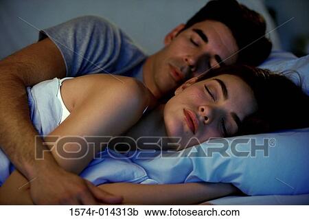 Close-up of a young couple sleeping on a bed View Large Photo Image Stock Image - Close-up of a young couple sleeping on a bed. Fotosearch