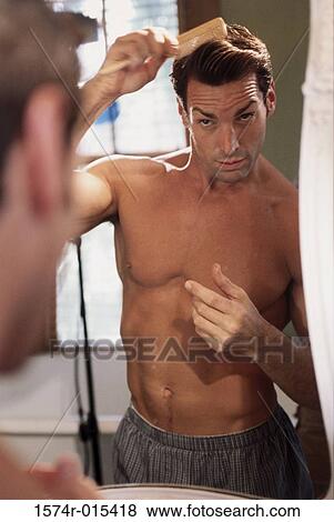 Close-up of a young man combing his hair in the bathroom View Large Photo Image Stock Photo - Close-up of a young man combing his hair in the bathroom. Fotosearch