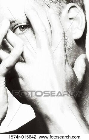 Close-up of a young man covering his face with his hands View Large Photo Image Stock Image - Close-up of a young man covering his face with his hands. Fotosearch