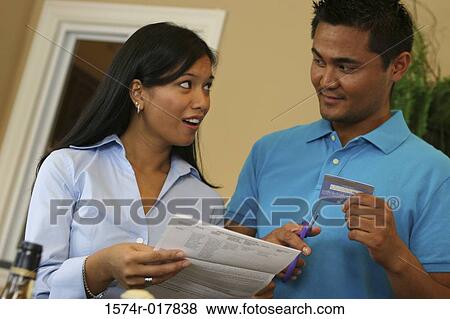 Close-up of a young man cutting a credit card with a pair of scissors View Large Photo Image Stock Photo - Close-up of a young man cutting a credit card with a pair of scissors. Fotosearch