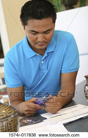 Close-up of a young man cutting a credit card with a pair of scissors View Large Photo Image Stock Photograph - Close-up of a young man cutting a credit card with a pair of scissors. Fotosearch
