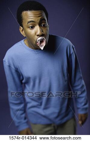 Close-up of a young man looking surprised with a burst bubble View Large Photo Image Picture - Close-up of a young man looking surprised with a burst bubble. Fotosearch