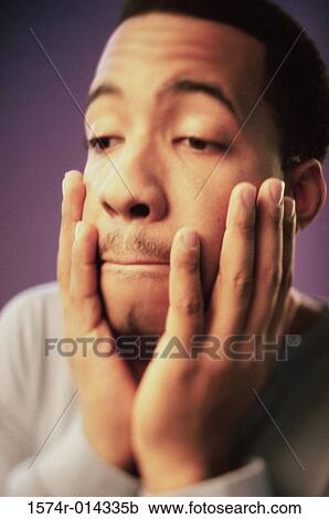Close-up of a young man looking sad View Large Photo Image Stock Image - Close-up of a young man looking sad. Fotosearch