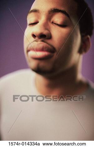 Stock Image - Close-up of a young man meditating. Fotosearch