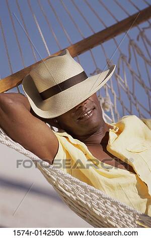 Close-up of a young man resting in a hammock View Large Photo Image Stock Image - Close-up of a young man resting in a hammock. Fotosearch