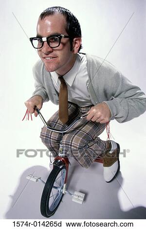 Stock Image - Close-up of a young man riding a tricycle. Fotosearch