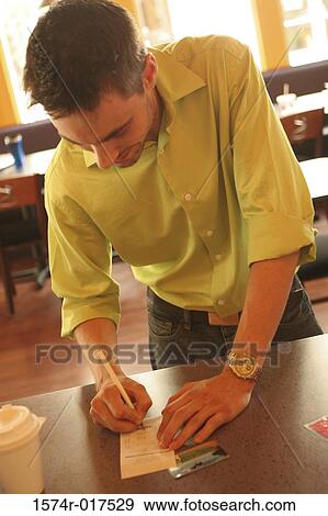 Close-up of a young man signing a bill View Large Photo Image Stock Photo - Close-up of a young man signing a bill. Fotosearch