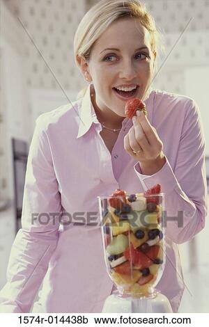 Close-up of a young woman eating a strawberry View Large Photo Image Stock Image - Close-up of a young woman eating a strawberry. Fotosearch