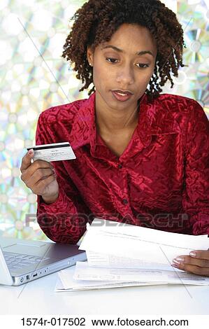 Close-up of a young woman holding a credit card and bills View Large Photo Image Stock Image - Close-up of a young woman holding a credit card and bills. Fotosearch
