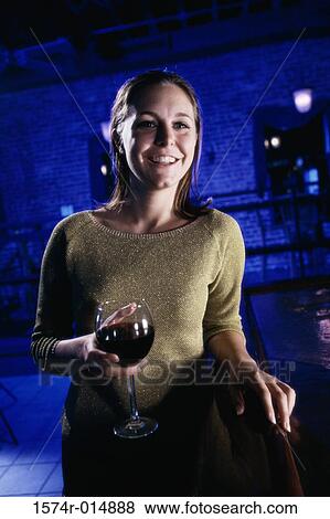 Stock Photo - Close-up of a young woman holding a glass of red wine. Fotosearch