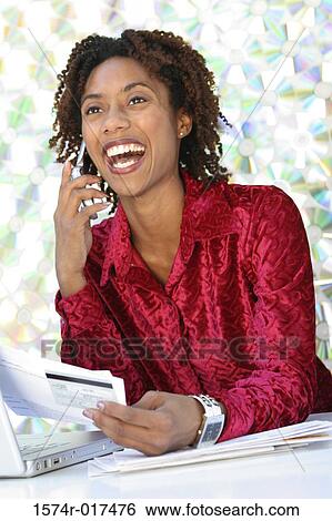 Close-up of a young woman holding a bill using a mobile phone View Large Photo Image Stock Photograph - Close-up of a young woman holding a bill using a mobile phone. Fotosearch